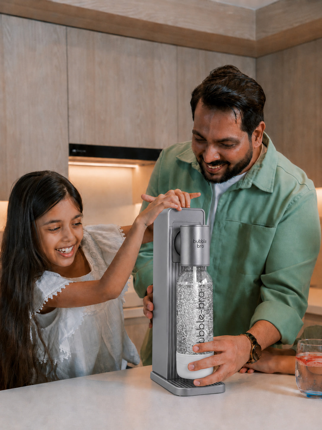Father and daughter carbonating fresh sparkling water with the bubble-bro Origin in black at home in their modern kitchen 
