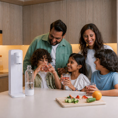 Family of five enjoying homemade sparkling water with fresh fruit in their kitchen - bubblebro Origin in black with two carbonating bottles 